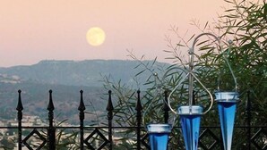 Une table dressée pour le dîner, avec une vue sur les montagnes et une pleine lune en arrière-plan.