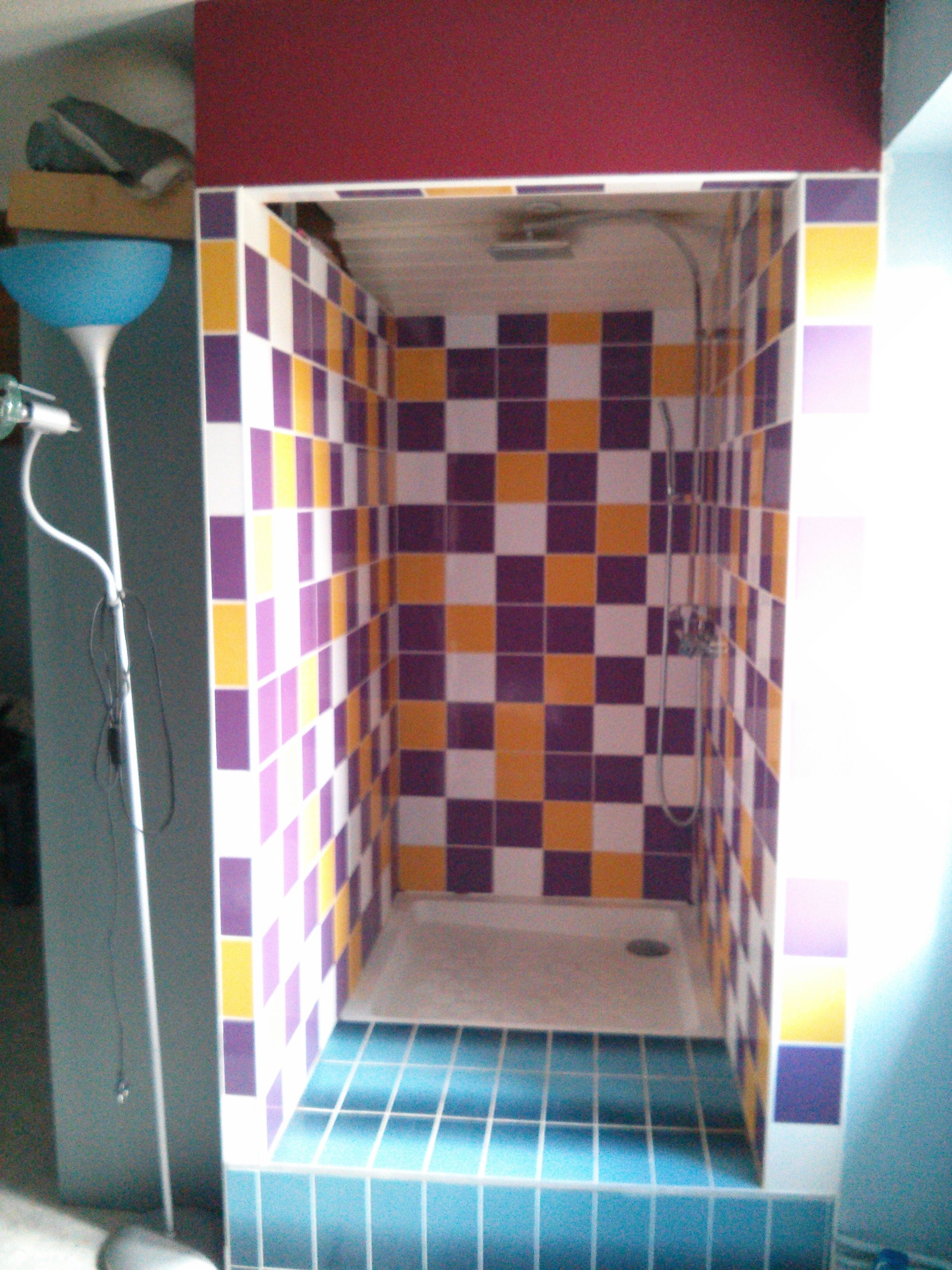 Un baño con piso de baldosas azules y un patrón de mosaicos a cuadros, y una ducha.