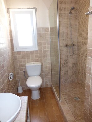 Een bad/douchecombinatie, een haardroger, handdoeken, zeep