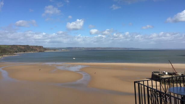 Ein Strand mit blauem Himmel und sanften Wellen.