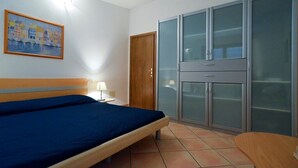 Une chambre à coucher avec un lit, une porte en bois et une armoire aux portes en verre.