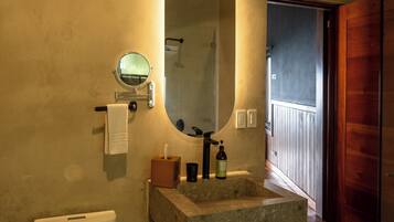 A bathroom with a toilet, a sink with a mirror, and a towel rack.