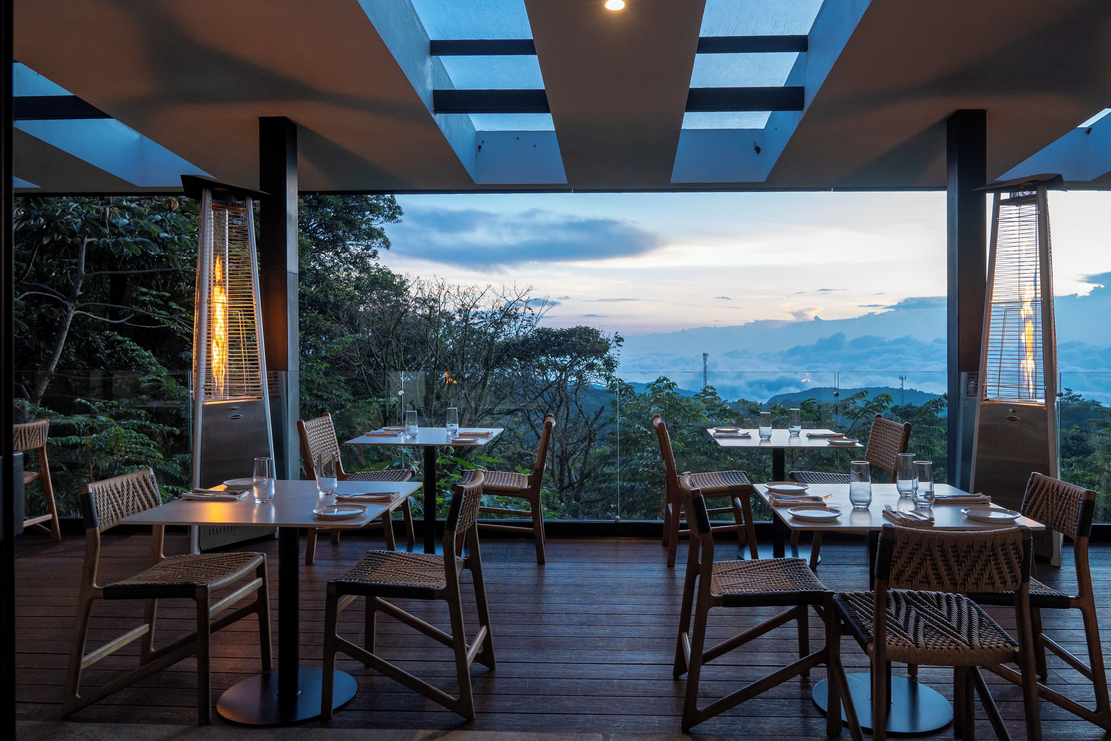 Un espace extérieur aménagé pour les repas, avec des tables et des chaises, offrant une vue sur un paysage montagneux.