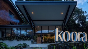 A modern building with a large sign reading "koora". - Koora Hotel by Sandglass (Monteverde)