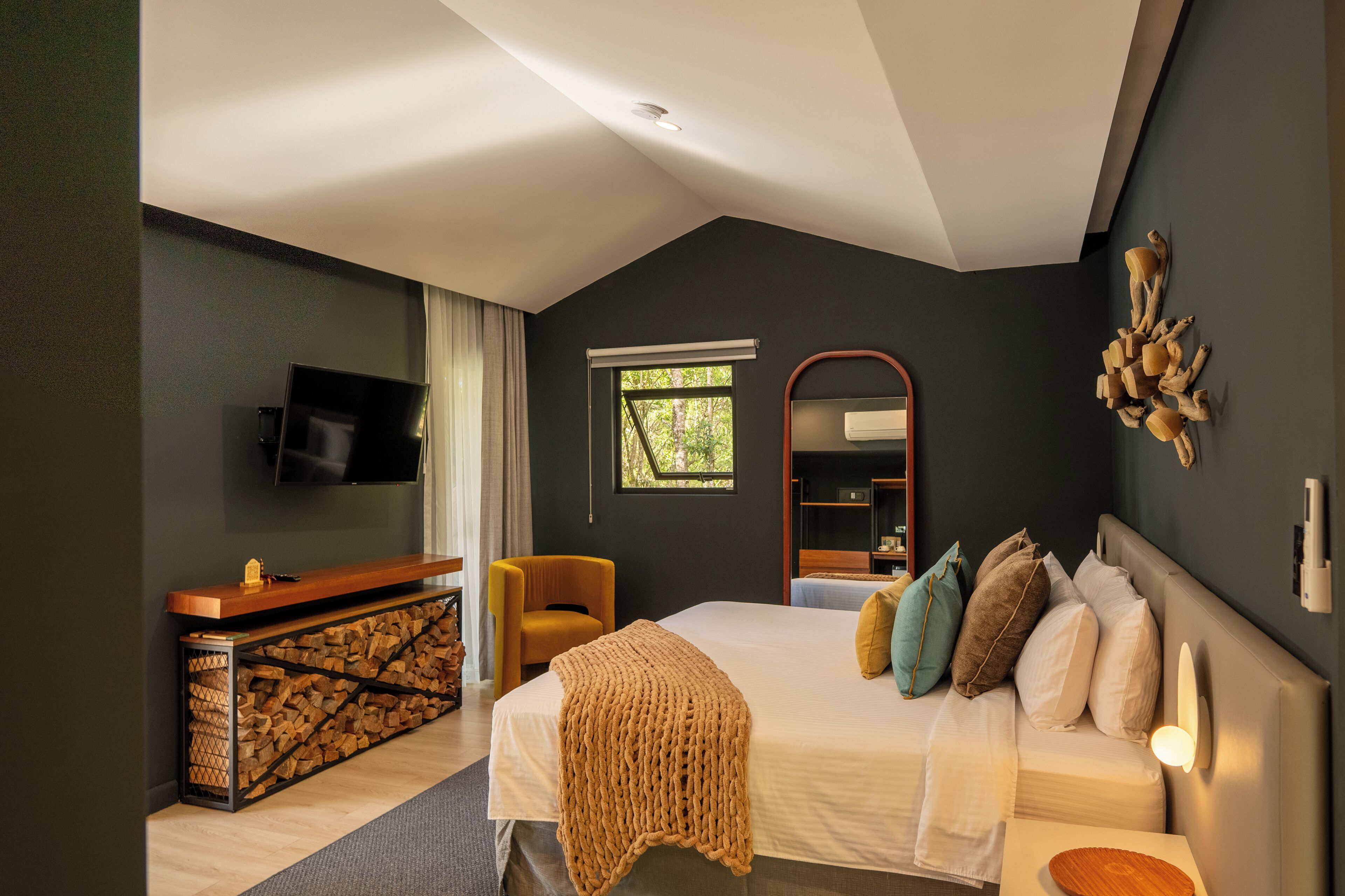 Ein modernes Schlafzimmer mit einem Bett, einem Schreibtisch und einem Fernseher.