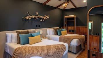 A hotel room with two beds, a wooden headboard, a ceiling fan, and a wall-mounted artwork.