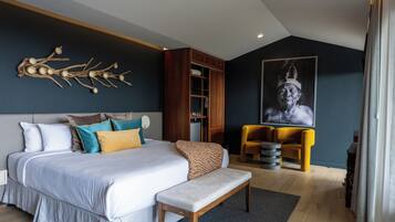 Un dormitorio moderno con una cama grande, un banco, un armario de madera y una pieza de arte única en la pared.