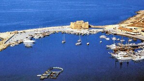 Un puerto costero con barcos amarrados y un edificio histórico en el centro.