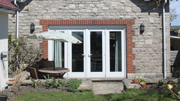 A stone house with a red-tiled roof, a chimney, and a front door with glass panels. - The Lookout - panoramic views; log fire; ONE-dog-friendly, local beaches. (Kingston)