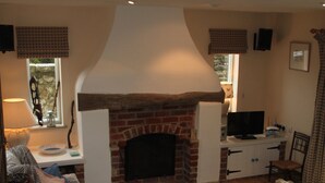 A living room with a fireplace, a television, and a comfortable seating area. - The Lookout - panoramic views; log fire; ONE-dog-friendly, local beaches. (Kingston)