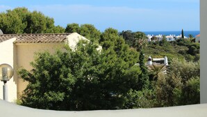 A coastal view with buildings, trees, and a clear sky. - Rustic apartment in Praia de Carvoeiro, Algarve (Carvoeiro)