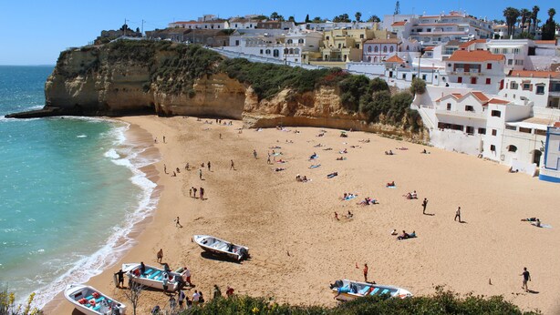 A coastal town with a sandy beach, boats, and buildings with red-tiled roofs. - Rustic apartment in Praia de Carvoeiro, Algarve (Carvoeiro)
