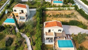 Un quartier résidentiel moderne composé de plusieurs maisons, chacune dotée d’une piscine et d’un jardin bien entretenu.