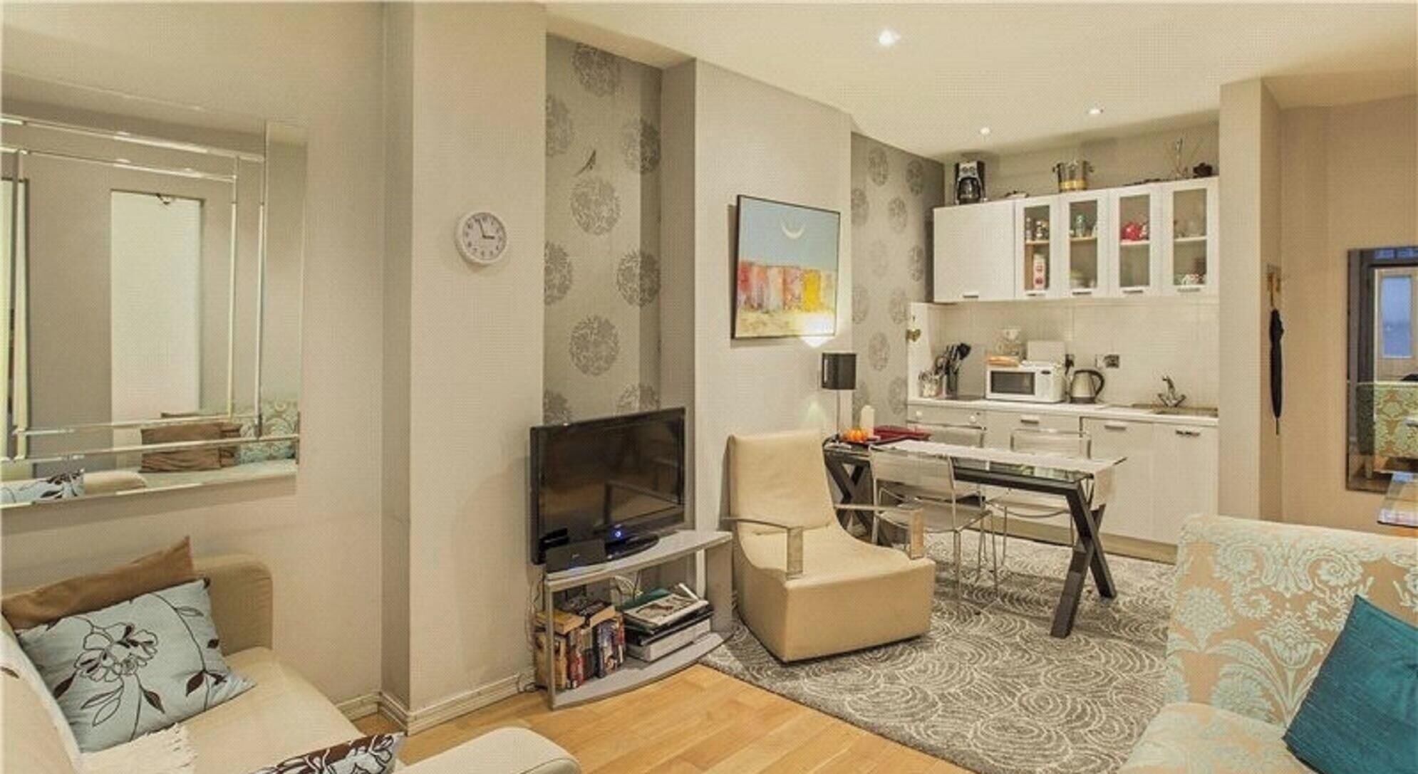 Una sala de estar moderna con un sofá, un sillón, un televisor y una estanter ía.
