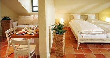 Un dormitorio con cama, mesita de noche y una silla.
