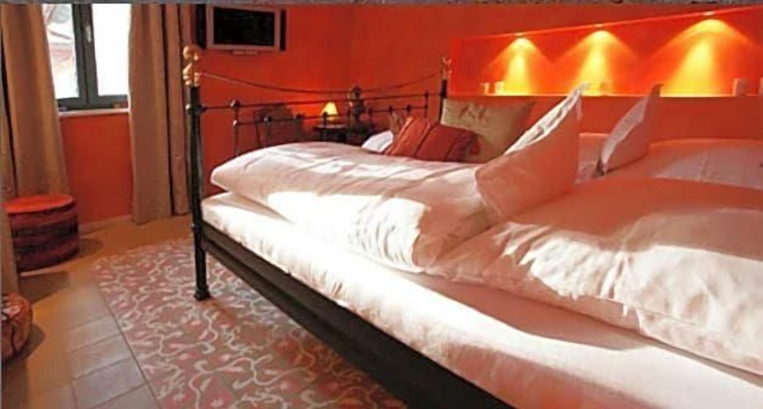 A bed with a headboard, a bedside table, and a wall-mounted television.