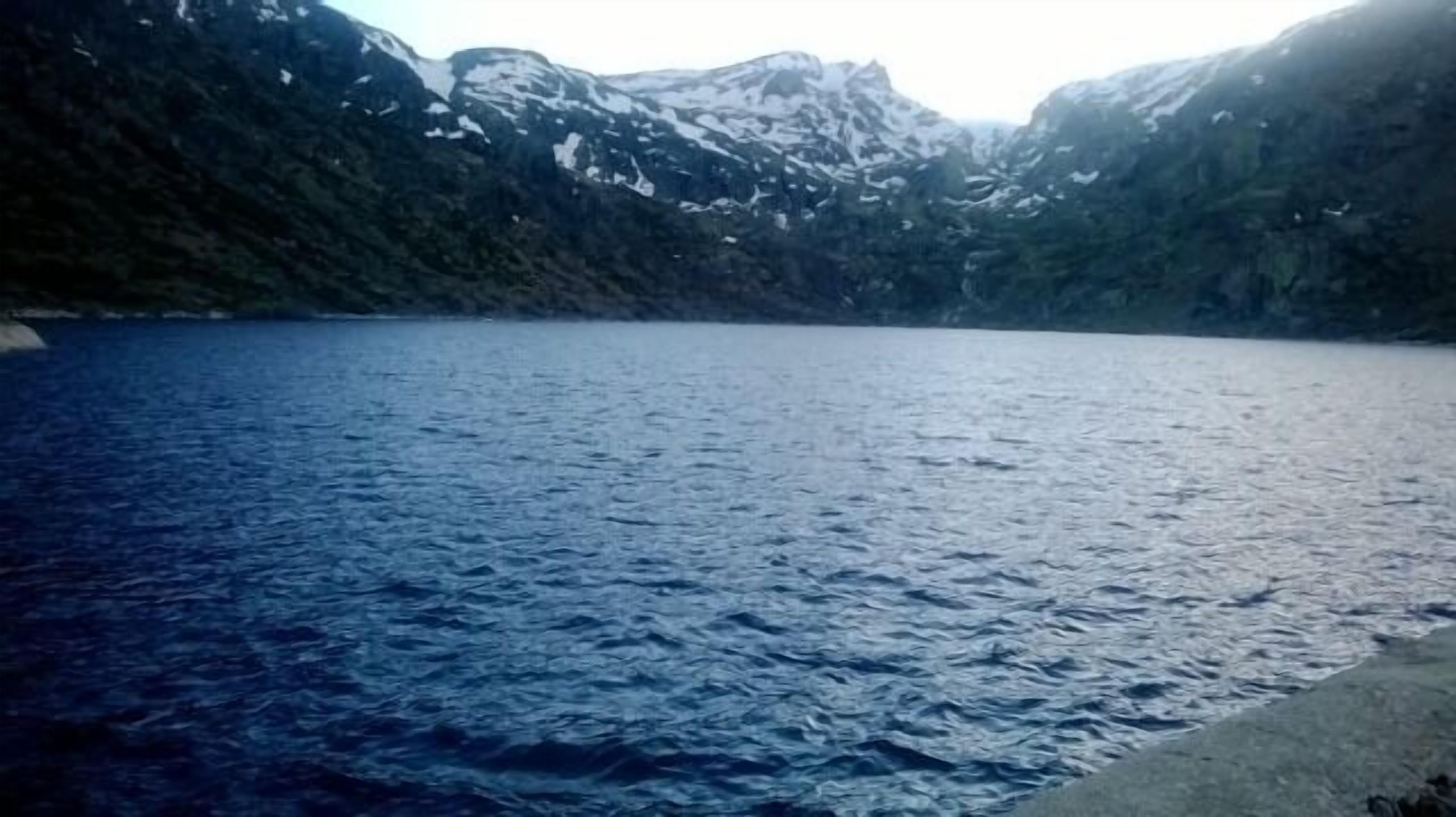 Un lac paisible, entouré de montagnes.