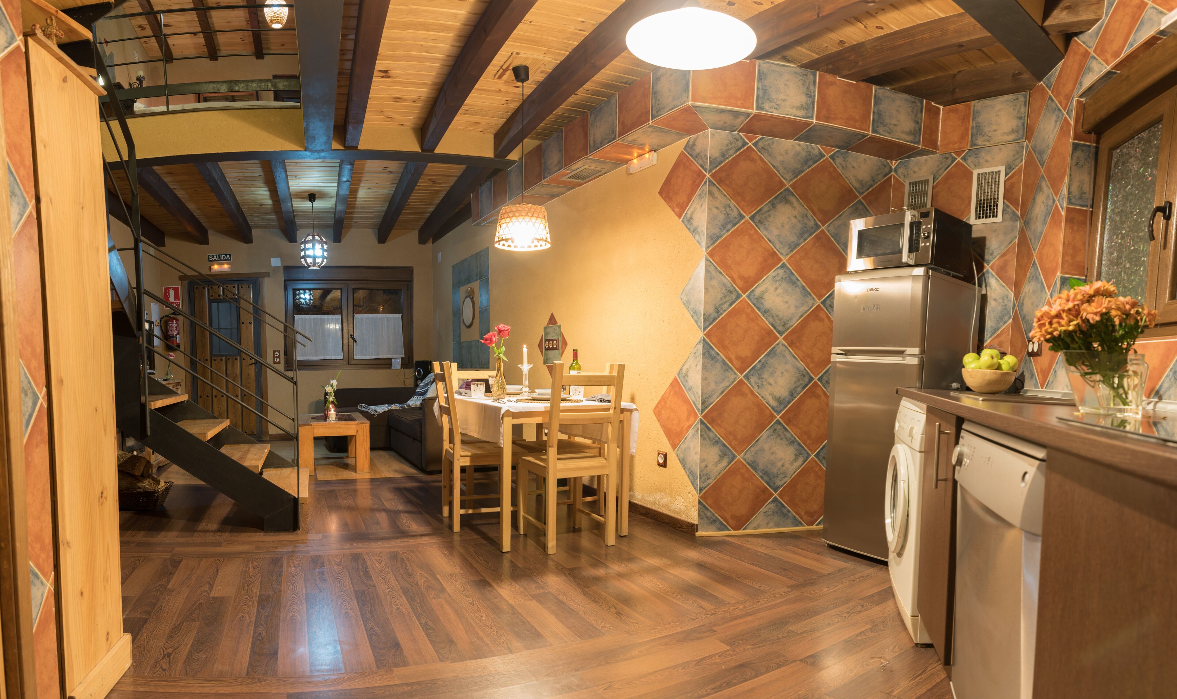 A modern kitchen with a built-in microwave, a refrigerator, and a washing machine.