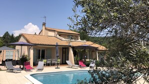 Ein Haus mit Schwimmbad, Sitzgelegenheit im Freien und Garten.