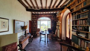Una biblioteca acogedora con estanterías, una mesa de madera y asientos cómodos.