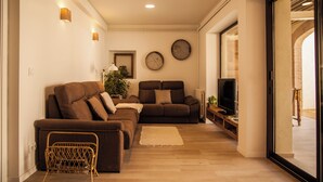 Ein Wohnzimmer mit zwei Sofas, einem Fernseher und einem kleinen Tisch.