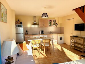 A compact living space with a kitchenette, a dining area, and a sofa.
