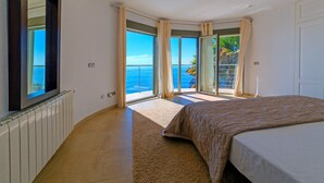 A bedroom with a large bed, a view of the sea through a sliding glass door, and a white radiator on the wall. - Villa Rosh, A luxury, 3 floor villa with majestic sea views this large villa is perfect for a large ... (Xàbia)