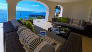A spacious living area with a view of the ocean, furnished with sofas, a coffee table, and a magazine. - Villa Rosh, A luxury, 3 floor villa with majestic sea views this large villa is perfect for a large ... (Xàbia)