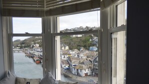 A view from a window with anchor pillows, overlooking a harbor with boats and buildings. - Beautiful 2 bed apartment, tastefully furnished with breathtaking views. (LOOE         CORNWALL)