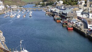 A harbor with boats, a bridge, and buildings along the water. - Beautiful 2 bed apartment, tastefully furnished with breathtaking views. (LOOE         CORNWALL)