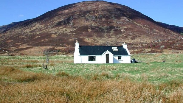 A white house with a black roof in a grassy field with a mountain in the background. - Isle of Skye Butt & Beinne for (second !) honeymooners or, getting away (Breakish)