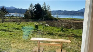 A bench in a grassy area with a view of a lake and mountains. - Isle of Skye Butt & Beinne for (second !) honeymooners or, getting away (Breakish)