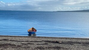 A boat on calm water, a shoreline with a flat surface, and distant land. - Isle of Skye Butt & Beinne for (second !) honeymooners or, getting away (Breakish)