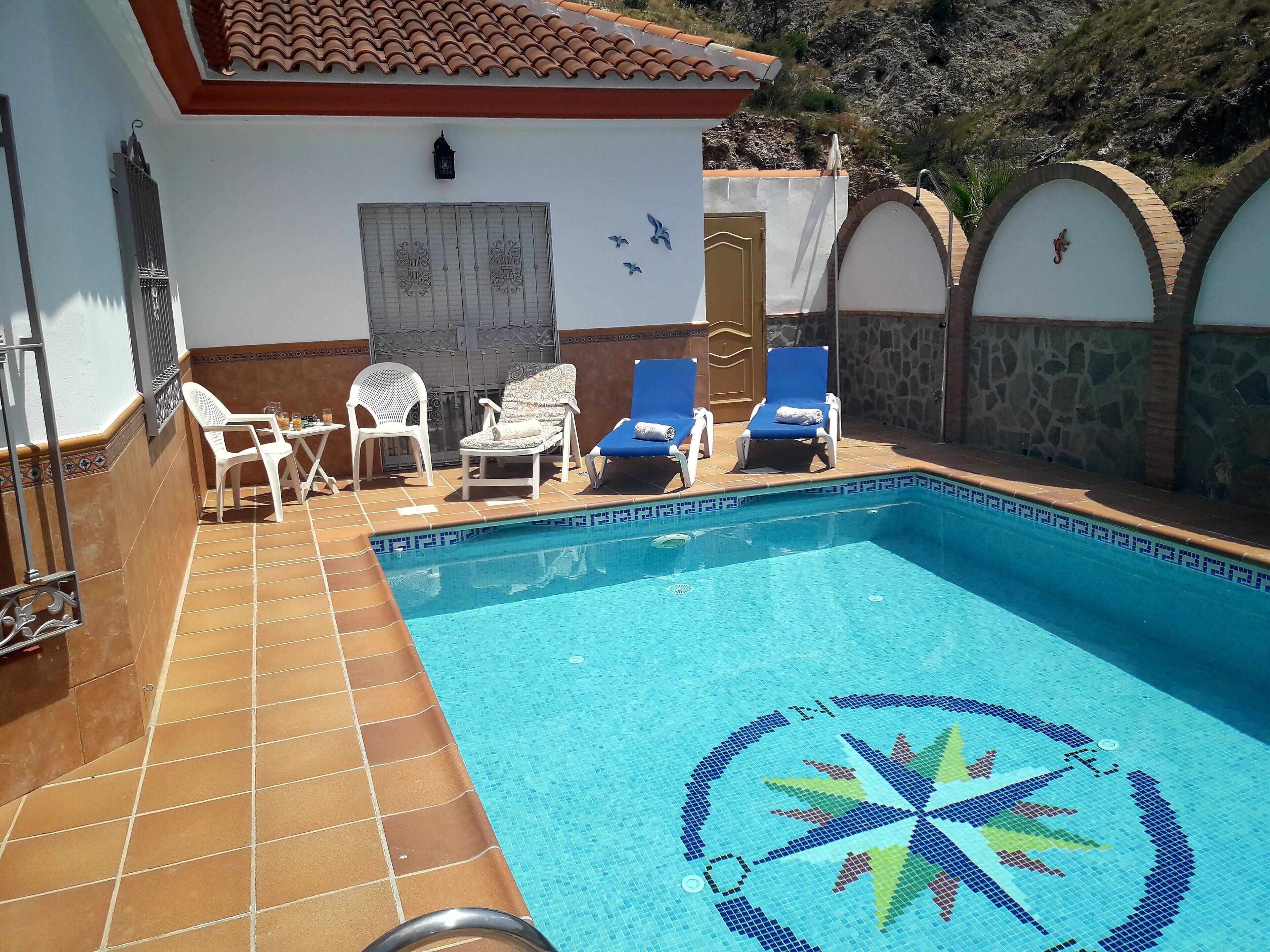 Una piscina amb un videt amb mosaic i un disseny decoratiu al centre.