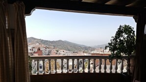 Ein Balkon mit Blick auf eine Stadt und Hügel.