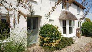 A white building with a thatched roof, a sign reading "Albury House," and a stone pillar. - Albury House -  Charmouth, Lyme Regis (Charmouth)