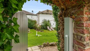 A garden view with a wooden gate, a lawn, and a brick wall. - Albury House -  Charmouth, Lyme Regis (Charmouth)