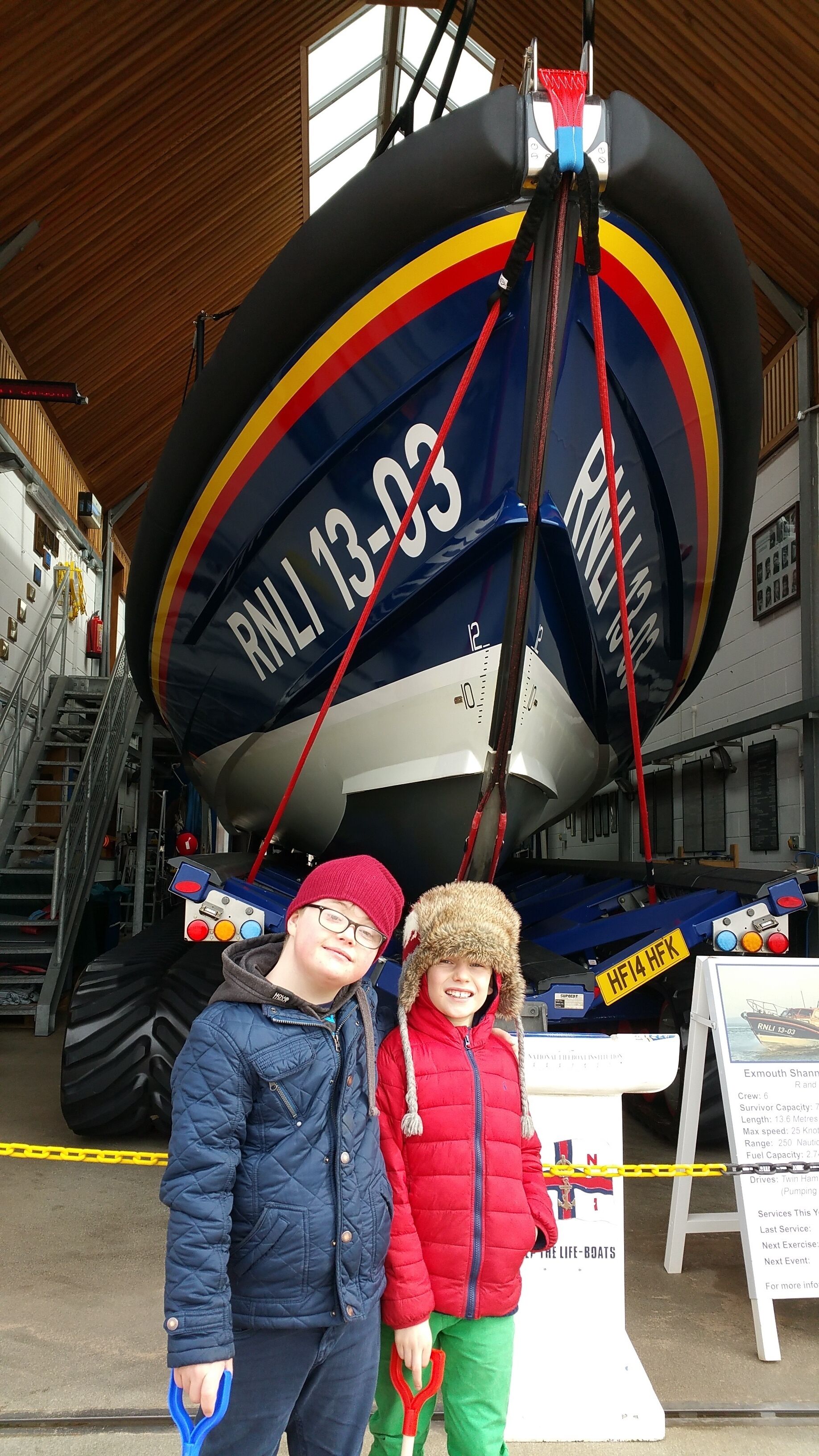 A boat with the registration RNLI 13-03, a control panel, and a signboard with boat details.