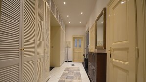 Un couloir avec un tapis à motifs, une porte dotée d’une fenêtre et un meuble.
