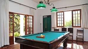 A pool table in a room with large windows, a door, and a chair. - FIFTH WITH PRIVATE POOL AND COURT TENNIS A 30 LISBON M (Vale do Paraíso)