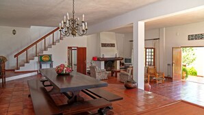 A spacious living area with a wooden dining table, a chandelier, and a staircase leading to another level. - FIFTH WITH PRIVATE POOL AND COURT TENNIS A 30 LISBON M (Vale do Paraíso)