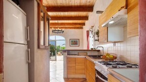 Una cocina con gabinetes de madera, una estufa a gas y un refrigerador.
