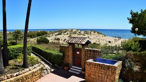 Edifici de pedra amb una piscina, envoltat d'un jardí ben cuidat i vistes a la platja.