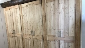 Une grande armoire en bois, dotée de plusieurs portes et de plusieurs poignées.
