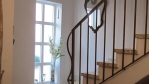 A dining area with a table set for two, a potted plant, and a staircase leading to an upper floor. - TOWNHOUSE WITH PATIOS, BBQ, FREE WIFI AND PARKING AT 5 'ON FOOT OF THE BEACH (Nerja)