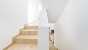 A modern staircase with a minimalist design, leading to a room with a white wall and a sofa. - This is Sea View !!! (Almancil)