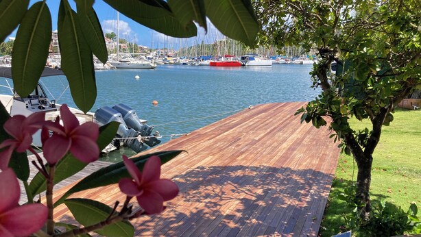 A wooden deck with a view of a marina and boats. - Exceptional villa with private sea access private swimming pool central position (GOSIER)