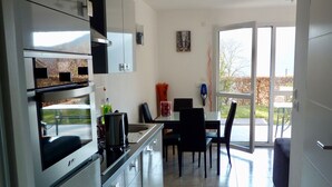 Una cocina moderna con comedor, ventanas amplias y vistas al exterior.