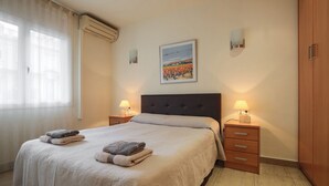 A hotel room with a bed, two bedside tables with lamps, a wardrobe, and a painting on the wall. - MARQUES, renovated, large, modern, 4 bedrooms flat for rent by days in Barcelona center, Eixample, Sant Antoni (Barcelona)