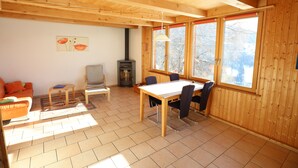 Un intérieur en bois comprenant une table à manger, des chaises, un canapé et une cheminée.